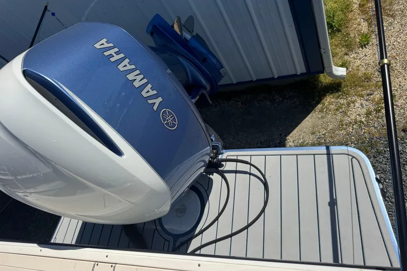Slide: The Image of Yamaha outboard motor on a 2002 Parker 2510 Walkaround boat, docked near a metal building. - 15