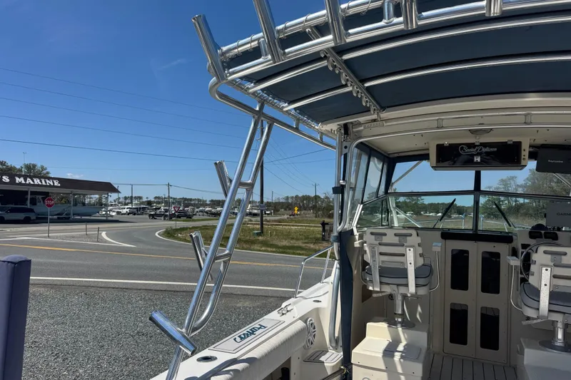 Slide: The Image of 2002 Parker 2510 Walkaround boat with seating, docked near a marine store. - 17