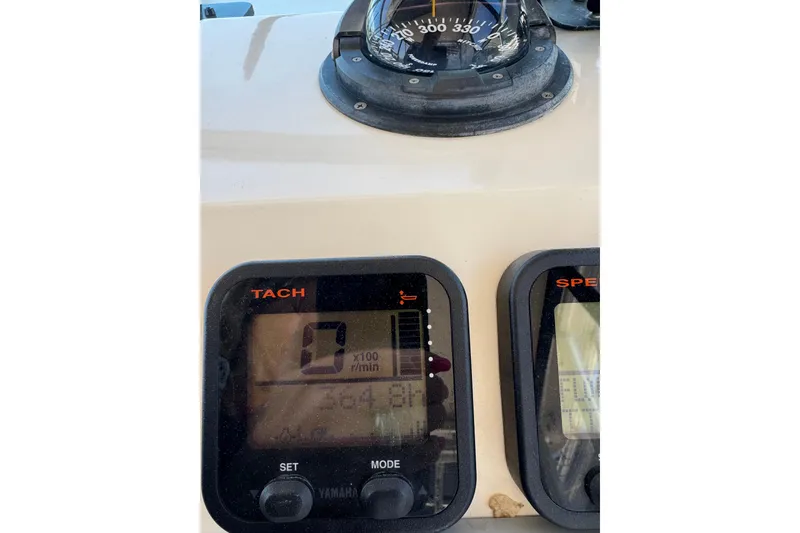 Slide: The Image of Dashboard of a 2002 Parker 2510 Walkaround boat with tachometer and compass. - 2
