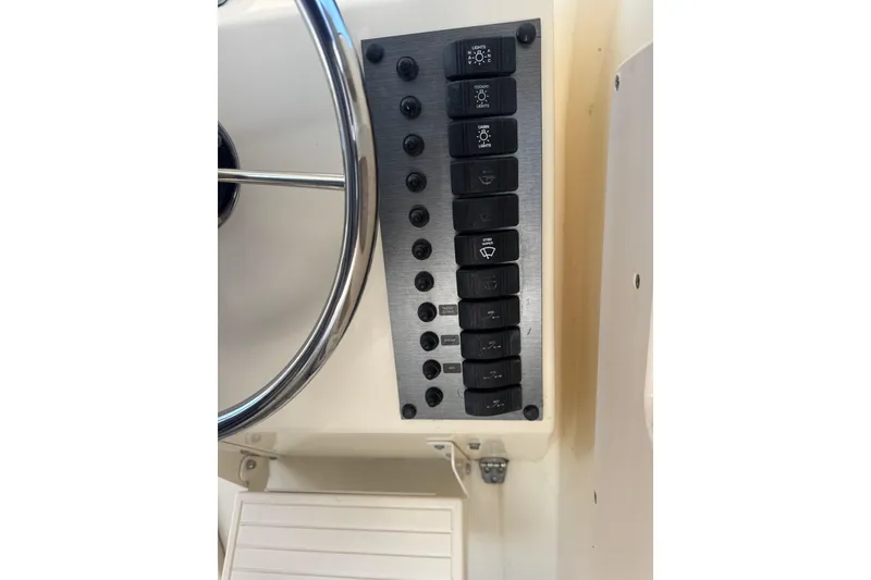 Slide: The Image of Control panel of a 2002 Parker 2510 Walkaround boat with steering wheel and switches. - 3