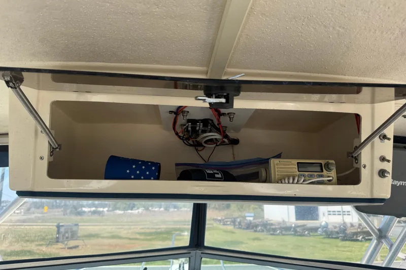 Slide: The Image of 2002 Parker 2510 Walkaround boat storage compartment with radio and cup holder. - 7