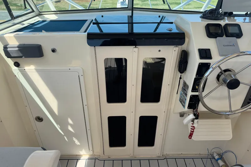 Slide: The Image of 2002 Parker 2510 Walkaround boat helm with steering wheel and Garmin navigation system. - 8