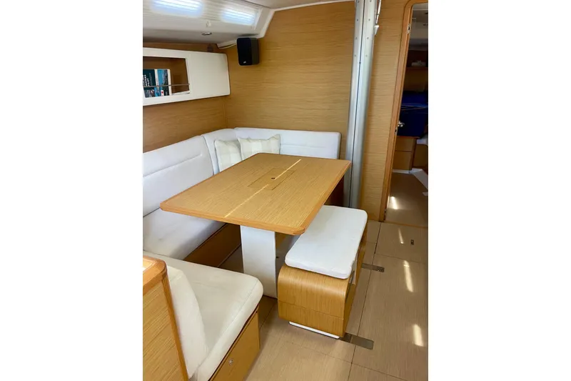 Slide: The Image of Interior of 2014 Grand Soleil 43F yacht with wooden dining area and white seating. - 27
