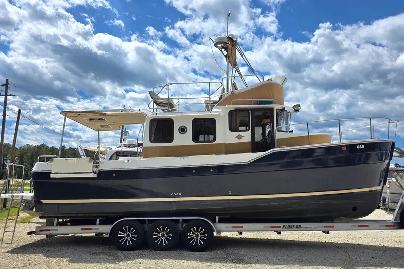 The Image of 2020 Ranger Tugs R-31 CB boat on trailer under a cloudy sky. - 0