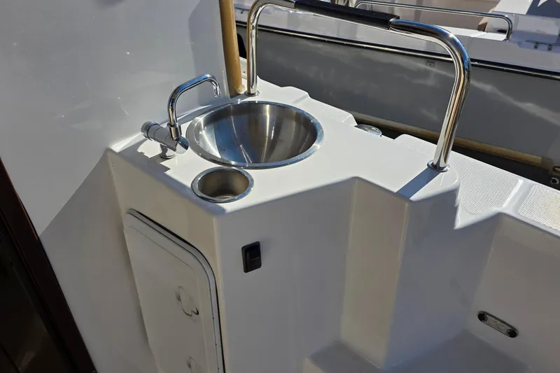 Slide: The Image of 2020 Ranger Tugs R-31 CB boat sink with stainless steel faucet and storage compartment. - 11