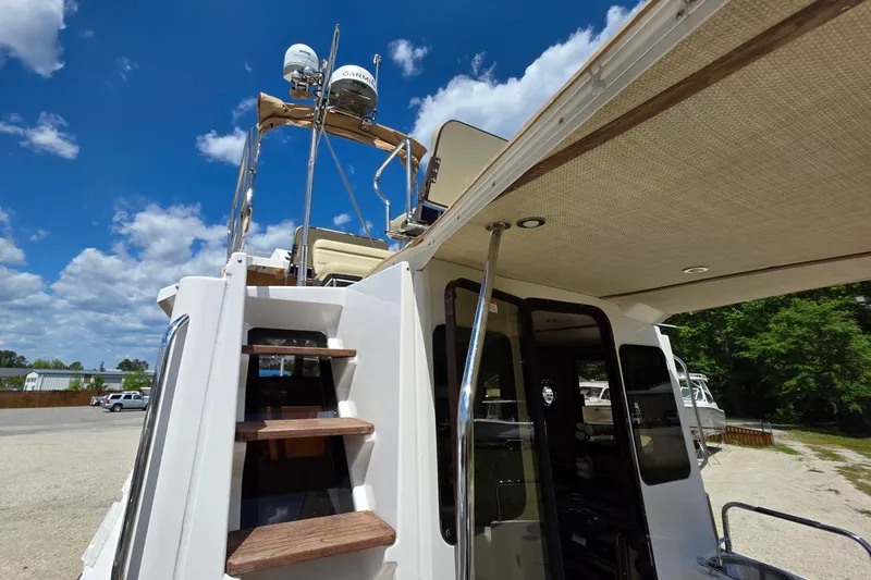 Slide: The Image of 2020 Ranger Tugs R-31 CB boat with upper deck and radar equipment under blue sky. - 13