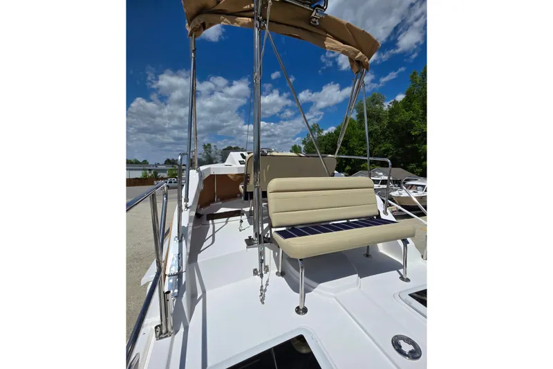 Slide: The Image of 2020 Ranger Tugs R-31 CB boat deck with seating and canopy under blue sky. - 14