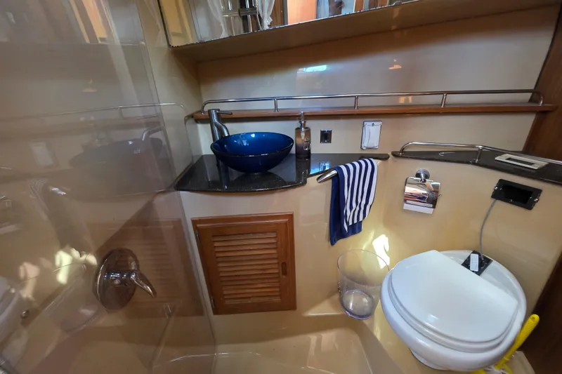 Slide: The Image of 2020 Ranger Tugs R-31 CB bathroom with blue sink, striped towel, and modern fixtures. - 39