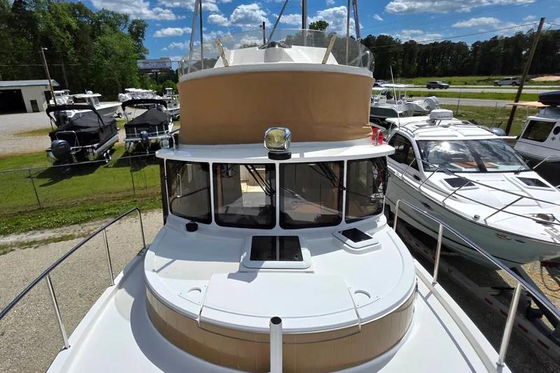 Slide: The Image of 2020 Ranger Tugs R-31 CB boat docked, surrounded by other vessels under a clear blue sky. - 4