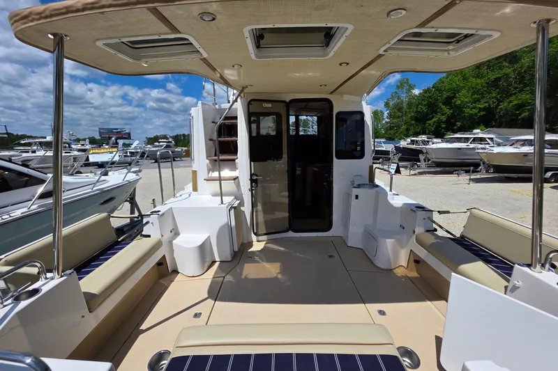 Slide: The Image of 2020 Ranger Tugs R-31 CB boat interior with seating, docked under a sunny sky. - 6