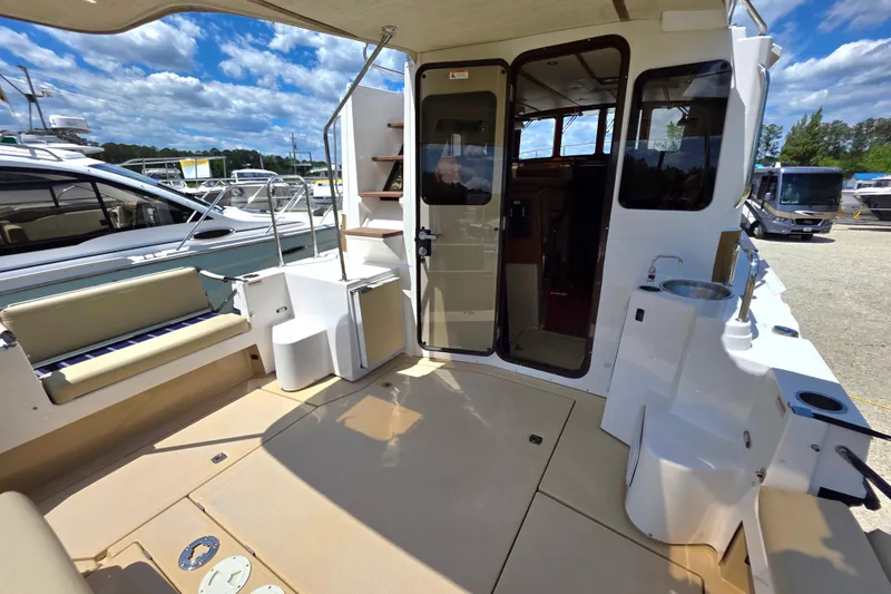 Slide: The Image of 2020 Ranger Tugs R-31 CB boat deck with seating, sink, and cabin entrance. - 7