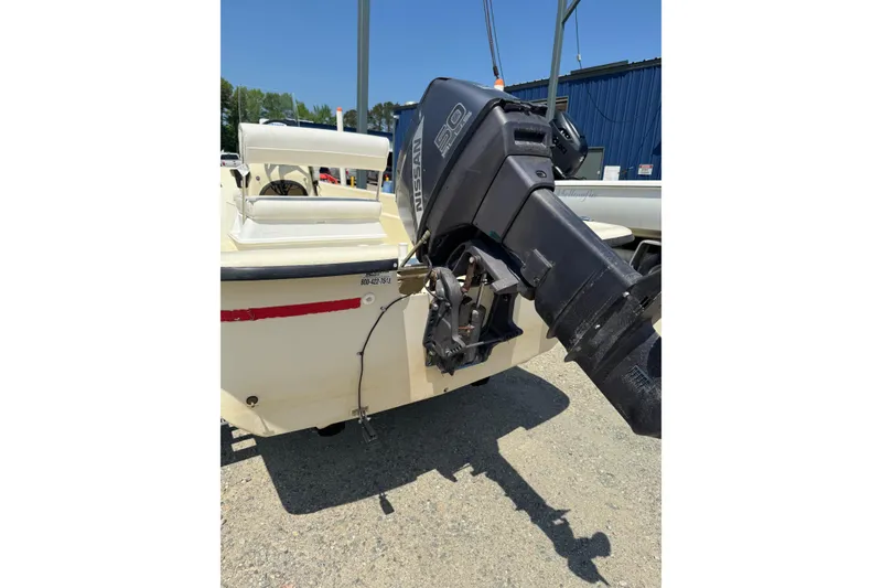 Slide: The Image of 1998 Carolina Skiff Semi-Vee 19 with Nissan outboard motor, parked outdoors. - 12