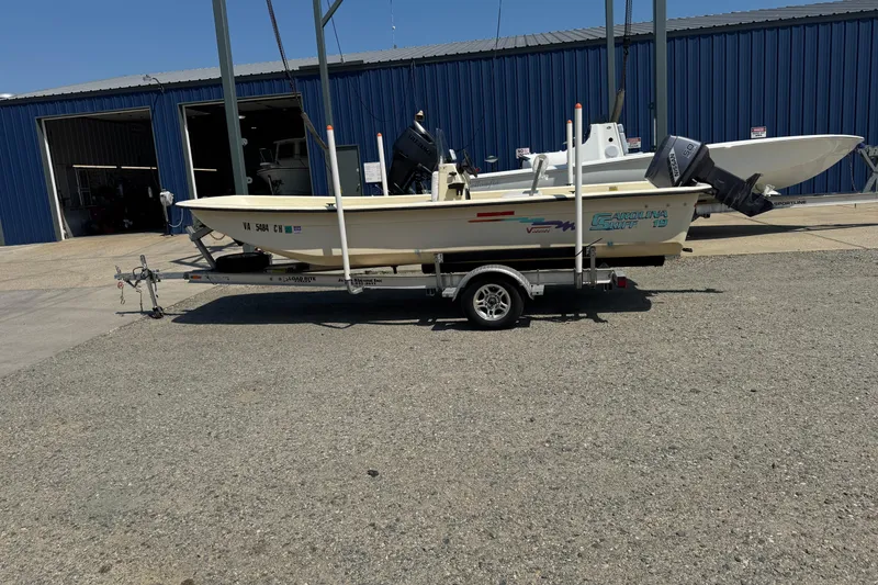 Slide: The Image of 1998 Carolina Skiff Semi-Vee 19 boat on trailer, parked outside a blue building. - 4