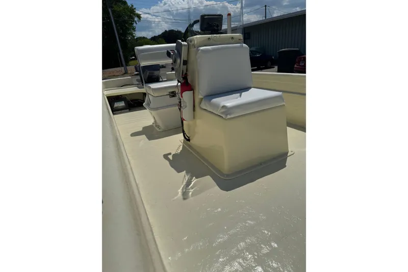 Slide: The Image of 1998 Carolina Skiff Semi-Vee 19 interior with seating and console, sunny day. - 7