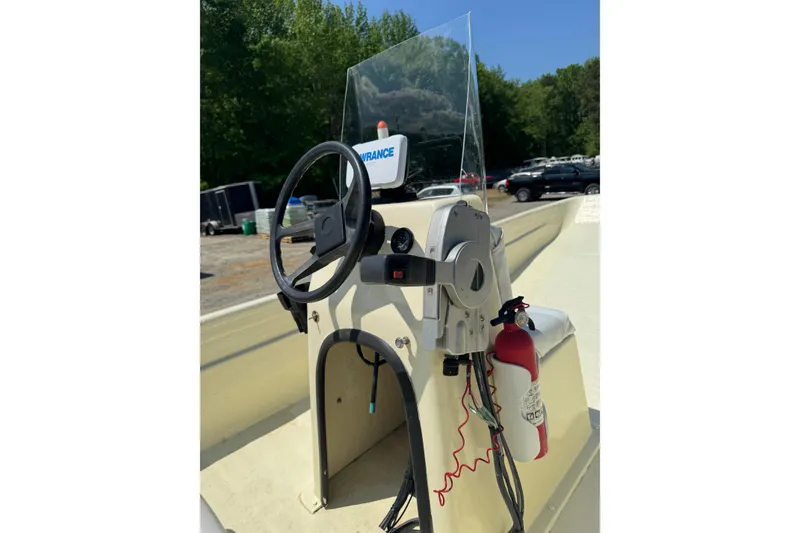 Slide: The Image of 1998 Carolina Skiff Semi-Vee 19 boat console with steering wheel and fire extinguisher. - 9