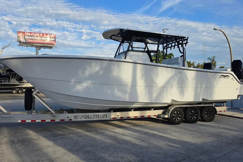 The Image of 2026 Invincible 33 Catamaran on trailer, parked outdoors under a clear sky. - 1