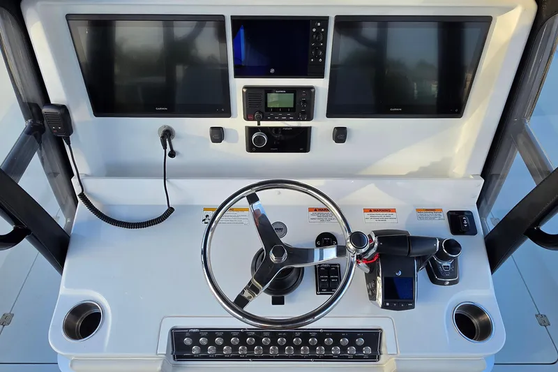 Slide: The Image of Helm of 2026 Invincible 33 Catamaran with dual screens and modern controls. - 15