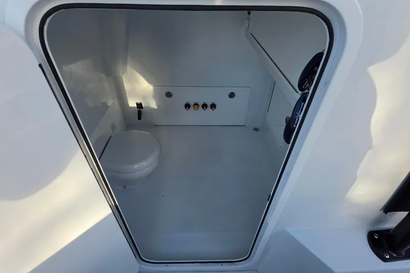 Slide: The Image of Interior of 2026 Invincible 33 Catamaran showing compact marine toilet space. - 20