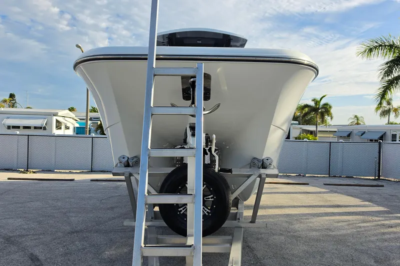 Slide: The Image of Front view of 2026 Invincible 33 Catamaran on trailer with ladder, palm trees in background. - 21