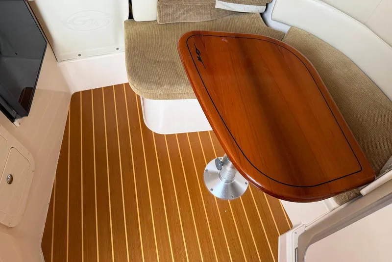 Slide: The Image of 2007 Grady-White Express 330 interior with wooden table and cushioned seating. - 11