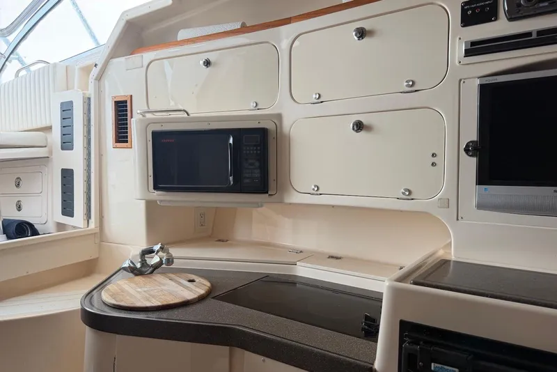 Slide: The Image of 2007 Grady-White Express 330 interior with microwave, cabinets, and cutting board. - 9