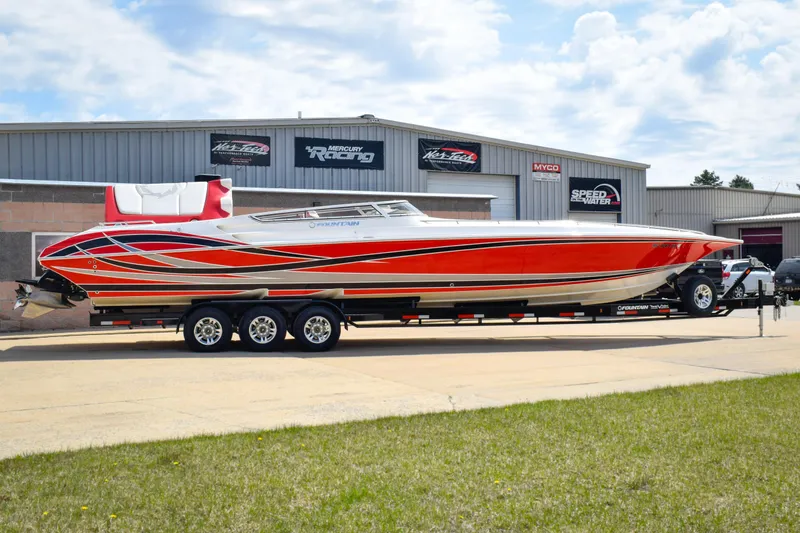 The Image of 2007 Fountain 42 Lightning speedboat with vibrant red and white design on a trailer. - 0