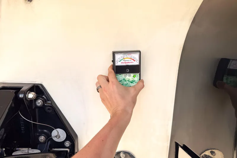 Slide: The Image of Hand using a moisture meter on a 2007 Fountain 42 Lightning boat hull. - 20