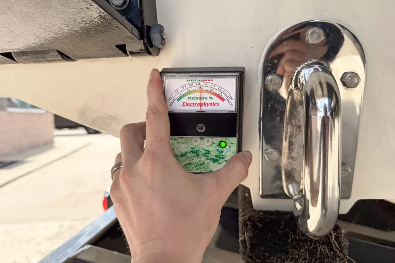 Slide: The Image of Hand holding moisture meter on 2007 Fountain 42 Lightning boat hull. - 23