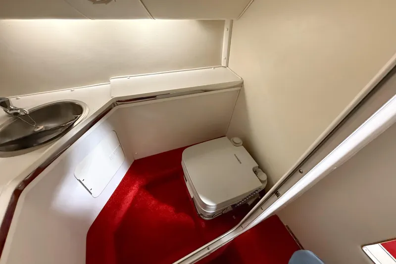 Slide: The Image of 2007 Fountain 42 Lightning boat interior with sink and portable toilet on red carpet. - 59