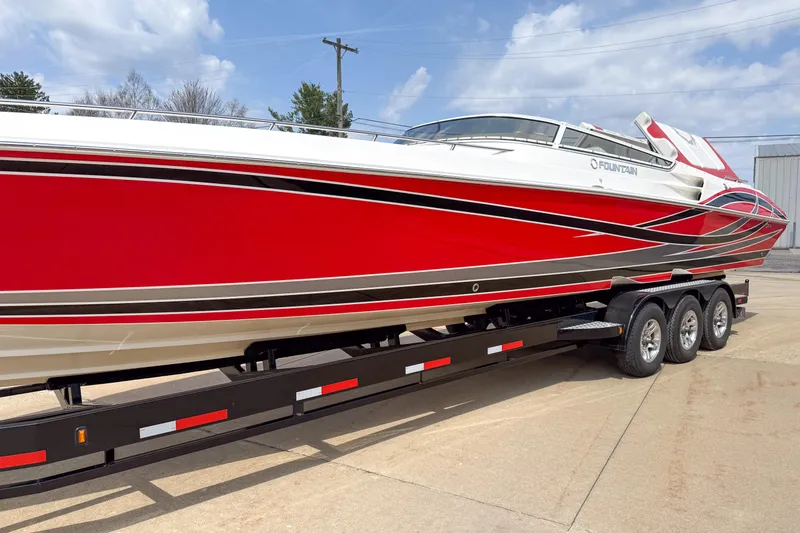 Slide: The Image of 2007 Fountain 42 Lightning speedboat in vibrant red on a trailer, parked outdoors. - 7
