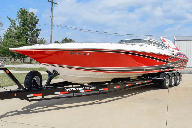 Slide: The Image of 2007 Fountain 42 Lightning speedboat on trailer, vibrant red and white design, parked outdoors. - 9