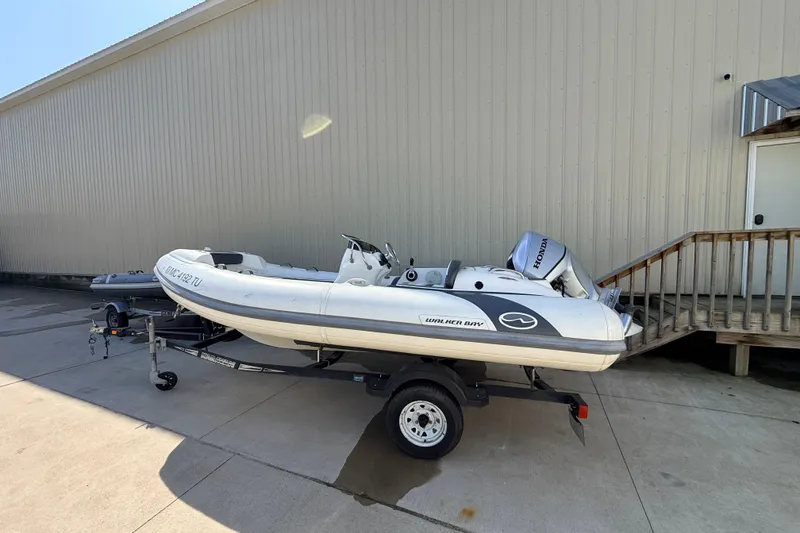 The Image of 2015 Walker Bay 450 Generation inflatable boat on trailer, parked outdoors. - 1
