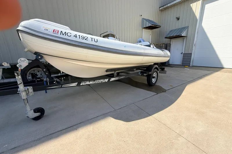 Slide: The Image of 2015 Walker Bay 450 Generation boat on trailer, parked outside a building. - 3