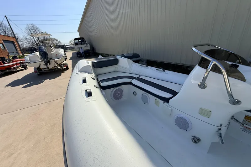 Slide: The Image of 2015 Walker Bay 450 Generation boat with seating and console, parked outdoors. - 7