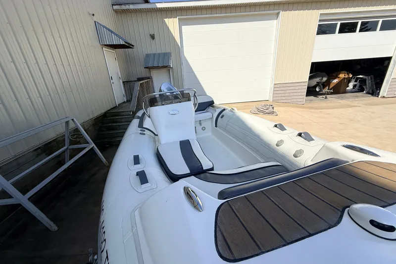 Slide: The Image of 2015 Walker Bay 450 Generation boat docked near a warehouse, showcasing sleek design. - 9