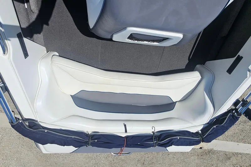 Slide: The Image of Interior of a 2000 Centurion Sport Bowrider boat, featuring white seating and a covered compartment. - 14