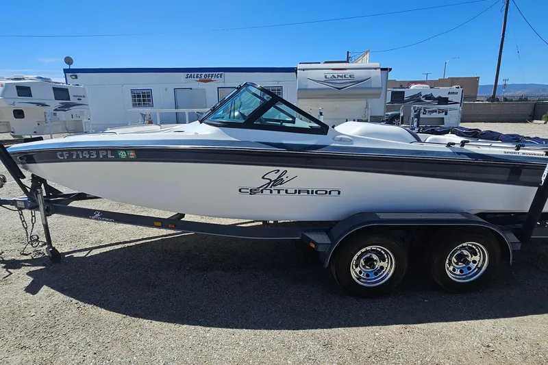 Slide: The Image of 2000 Centurion Sport Bowrider boat on trailer, parked near sales office. - 3