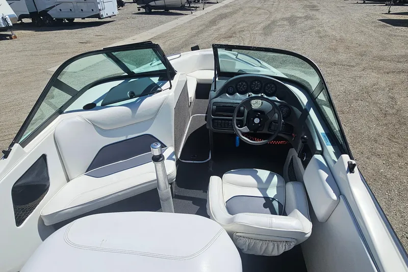 Slide: The Image of 2000 Centurion Sport Bowrider interior with steering wheel and seating, parked outdoors. - 7