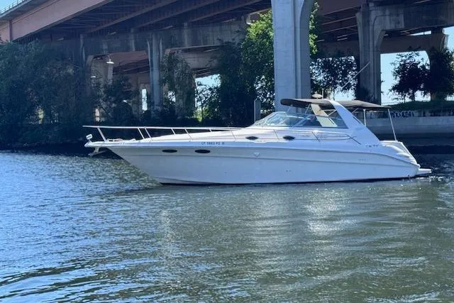 Slide: The Image of 1998 Sea Ray Sundancer 330 yacht on a calm river under a bridge. - 2