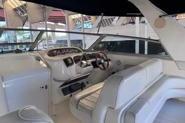 Slide: The Image of 1998 Sea Ray Sundancer 330 cockpit with white seating and wooden steering wheel. - 26