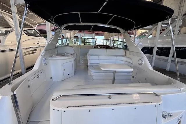 Slide: The Image of 1998 Sea Ray Sundancer 330 interior with seating and canopy in a marina setting. - 28
