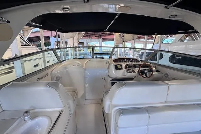 Slide: The Image of 1998 Sea Ray Sundancer 330 interior with white seating and helm under a black canopy. - 29