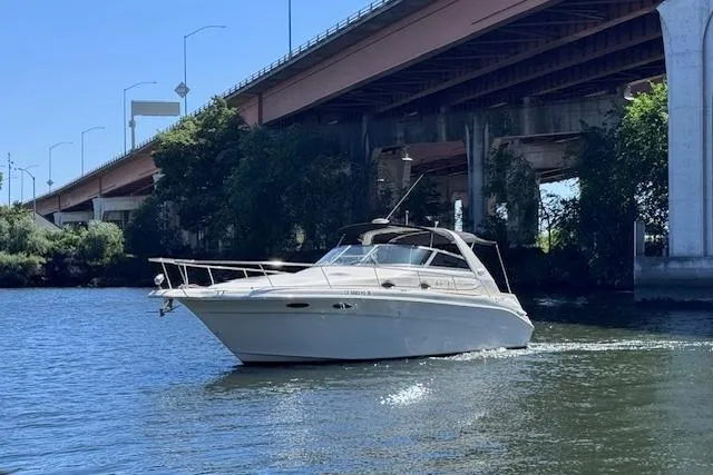 Slide: The Image of 1998 Sea Ray Sundancer 330 cruising under a bridge on a sunny day. - 3