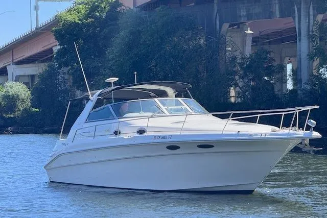 Slide: The Image of 1998 Sea Ray Sundancer 330 cruising on a river under a bridge. - 4