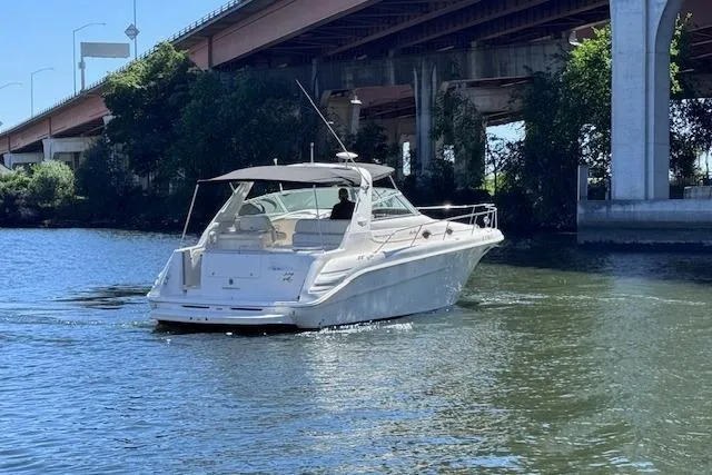 Slide: The Image of 1998 Sea Ray Sundancer 330 cruising under a bridge on a sunny day. - 7