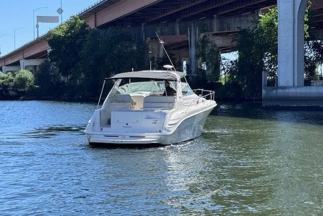 Slide: The Image of 1998 Sea Ray Sundancer 330 cruising under a bridge on a sunny day. - 8