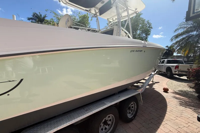 Slide: The Image of 2007 Boston Whaler 270 Outrage boat on trailer, parked outdoors under clear sky. - 10