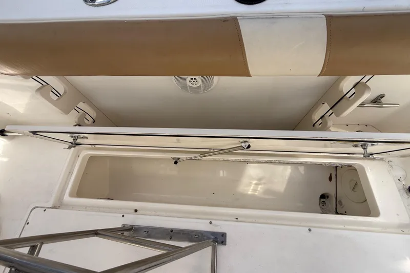 Slide: The Image of 2007 Boston Whaler 270 Outrage interior storage compartment with open hatch and seating. - 100