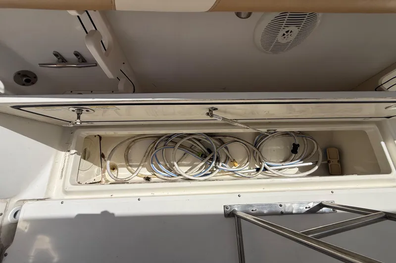 Slide: The Image of Storage compartment on a 2007 Boston Whaler 270 Outrage boat with coiled cables. - 101