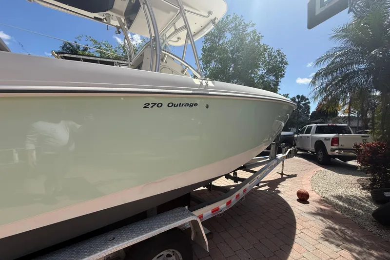 Slide: The Image of 2007 Boston Whaler 270 Outrage boat on trailer, sunny day, palm trees in background. - 11